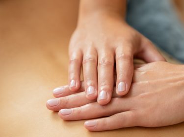 Nahaufnahme von Händen bei einer Wellness-Massage auf einem Rücken.