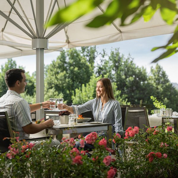 Paar genießt ein gemeinsames Essen auf der Gartenterrasse des Hotel Sonnengut in Bad Birnbach.
