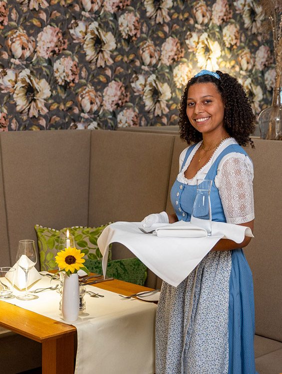 Mitarbeiterin des Sonnenguts mit Tablett im Restaurant