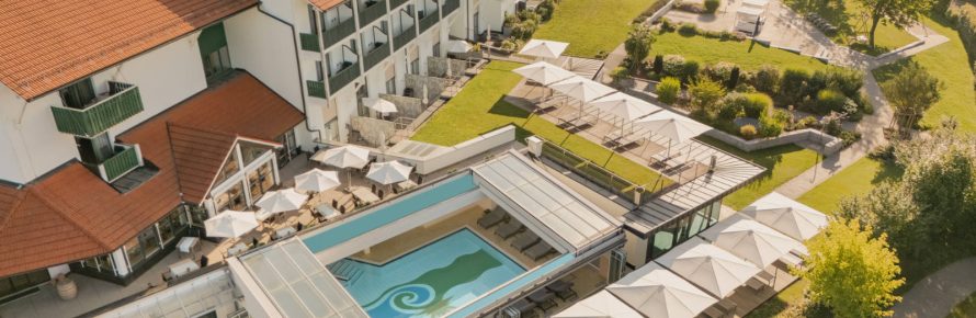 Sicht von oben auf das Hotel Sonnengut, den Pool und den angrenzenden Garten